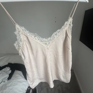 Beige linne med spetsdetaljer - Gulligt beiget spetslinne som inte kom till användning hos mig. En liten fläck som man ser på den andra bilden, detta gör såklart att priset går ner!💞💞