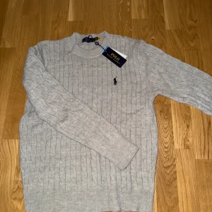 Ralph lauren cable knit tröja - Säljer nu denna gråa helt nya kabelstickade ralph lauren tröjan. Den är i strl M. Bara att skriva ett DM vid intresse!
