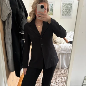 Svart kavaj från Gina Tricot - Snygg svart kavaj från Gina Tricot i storlek 38. Kavajen har en klassisk design med två knappar framtill och en figursydd passform. Aldrig använd🖤🖤🖤