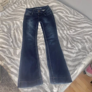 Lågmidjade bootcut jeans - Midjemått 34 men ganska stretchiga, innerbenslängden är 81 cm. Står storlek 38 på byxorna men skulle säga att de är mer 36/34 passar alltså S. Köpta secondhand men har inga defekter. Cool bakficka.