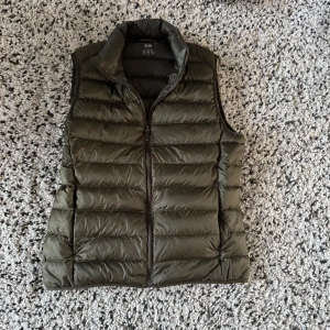 Olivgrön väst - Uniqlo - Säljer en olivgrön dunväst från Uniqlo. Västen är i storlek S men sitter som xs. Hör av er vid frågo , självklart kan pris diskuteras !!
