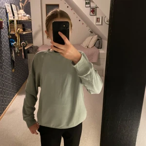 grå/grön sweatshirt  - Säljer en stilren grå/grön sweatshirt med rund hals och långa ärmar. Perfekt för en avslappnad look. Tröjan har ribbade muddar vid ärmslut. 💗