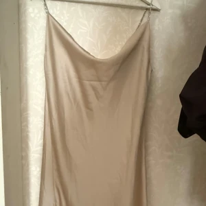 Beige klänning från Eight Paris - Elegant beige klänning från Eight Paris med tunna axelband och en mjuk, draperad halsringning. Perfekt för en stilren look. Ny med prislapp på 