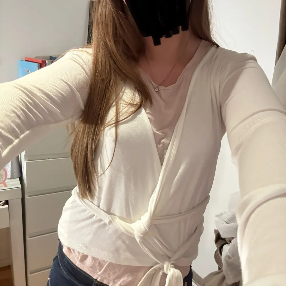 Säljer en stilren vit omlottkofta med knytband i midjan. Koftan har långa ärmar och är perfekt för lager-på-lager-stil. Passar bra till både jeans och kjol.(Vet ej hur den ska knytas)🩷. Neuletakit & Villapaidat.