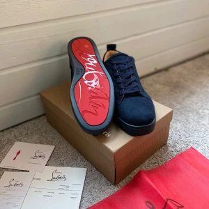 Sjukt feta mörkblå Louboutins - Feta mörkblå sneakers från Christian Louboutin med den ikoniska röda sulan i storlek 44. Skorna har snörning och är tillverkade i mocka, vilket ger en lyxig känsla. Perfekta för en trendig look. Sjukt feta nu inför våren och sommaren, så passa på 🏖️Skriv om ni har frågor eller funderingar! 💬Priset går såklart att diskutera! 🤝