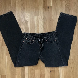 Lågmidjade Svarta jeansbyxor från weekday - Snygga svarta jeansbyxor från weekday med klassisk design. Byxorna har en rak passform och är lågmidjade samt är tillverkade i slitstarkt denim. Perfekta för en stilren look.