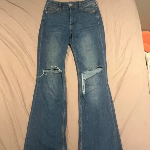 Blå flare jeans - Snygga blå flare jeans med mellan hög midja. Byxorna har slitna detaljer på knäna. I storlek 25/30 från Kappahl🩷strechigt material!