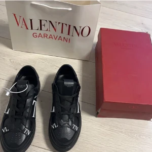 Valentino Skor - Snygga svarta sneakers från Valentino Garavani med vita detaljer och logotyp. Skorna har snörning och en stilren design som passar perfekt för en trendig look. 