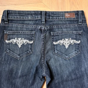 Lågmidjade jeans - Snygga blå jeans från Paige med broderade detaljer 🤩Dark wash, låg midja, bootcut ✨✨Måtten finns på bild!! Säljer då de inte passar mig