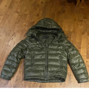 Olivgrön pufferjacka från Bvaldi  - En otroligt snygg olivgrön pufferjacka från Bvaldi i storlek XS. Jackan har huva, två dragkedjefickor framtill och coolt logomärke på ärmen. Perfekt för kalla dagar så som höst och vinter med sin quiltade design och rejäla dragkedja framtill, skick 9/10 som ny! nypris ligger på 2999kr. Väl värt pengarna/Fashion Clothing ✅
