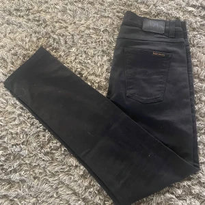 Nudie Jeans svarta jeans – slim fit herr - 🧼 Skick: Mycket bra skick – inga hål eller fläckar. Välvårdade och endast använda ett fåtal gånger. 📏 Storlek: W30 L34 🎨 Färg: Svart 👖 Modell: Slim fit med stretch, från Nudie Jeans 📍 Detaljer: Mjuka och bekväma jeans med Nudies klassiska söm på bakfickorna. Stilrena och passar till allt. 🌿 Material: Ekologisk bomull (Nudie fokuserar på hållbar produktion) 📫 Frakt: Skickas snabbt och noggrant packat. 💬 Frågor? Skriv gärna om du vill ha fler bilder eller må
