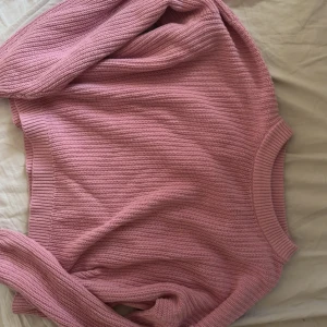 Rosa stickad tröja i loose fit - Mysig rosa stickad tröja med rund hals och avslappnad passform. Tröjan har ribbade muddar vid ärmslut och nederkant, perfekt för lager på lager. Enkel och stilren design som är lätt att matcha. Tröjan kan ha nån fläck på sig men inget man tänker på och dom nog går bort i tvätten❤️