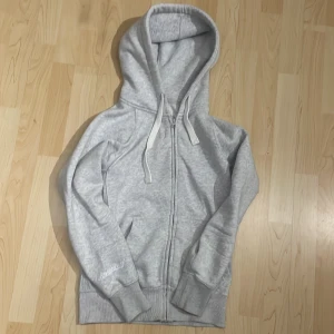 Ljusgrå hoodie från Russemerch - Ljusgrå tröja från russemerch. Säljer för att den inte riktigt kommer till användning. Jättesnygg och nästan helt ny. Köpt tidig sommar