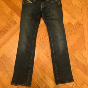 Diesel jeans  - Lågmidjade Diesel jeans i mörkblå tvätt med raka ben och snygga slitningar. Storlek W27💕