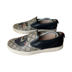 Gucci slip ons  - Gucci Canvas monogram slip on. Storlek 8 / 41. Skick 7/10 använda men fint skick. Pris 1349kr finns att köpa på våran hemsida, Fashionels.com 