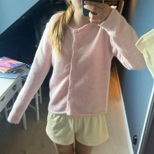 Ljusrosa kofta från Gina Tricot - Supermjuk och mysig ljusrosa kofta från Gina Tricot. Koftan är stickad, har långa ärmar och knäpps med matchande rosa knappar framtill. Perfekt för lager-på-lager och chill dagar. Endast använd fåtal gånger