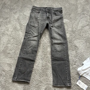 Replay grå jeans straight fit - Säljer ett par grå jeans från Replay med snyggt tvättad look och klassiska fem fickor. Jeansen har rak passform, dragkedja och knapp i midjan. Materialet är mjukt jeans-tyg som sitter skönt hela dagen. Perfekta till sneakers och hoodie. Dock har dom inga lappar då jag klippt bort dom men funkar lika bra, storlek 146