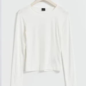 Vit långärmad tröja - En stilren vit långärmad tröja från gina med rund halsringning. Perfekt basplagg och påminner om den från intimissimi.