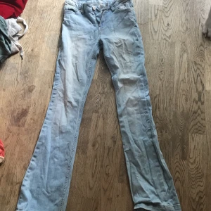 Ljusblå bootcut jeans lågmidjade 💕 - Säljer ett par ljusblå jeans med bootcut-modell. Klassisk femficksdesign, dragkedja och knapp framtill. Jeansen har en avslappnad passform och är tillverkade i mjukt denimtyg. Perfekta för dig som gillar en retro vibe och vill ha ett par riktigt sköna jeans.