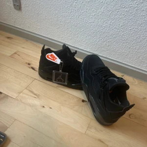 Nike Air Jordan 4 Retro Black Cat - Säljer ett par Nike Air Jordan 4 Retro Black Cat sneakers i helsvart färg. Helt nya och är originala säljer dom pga av att storleken it passar mig