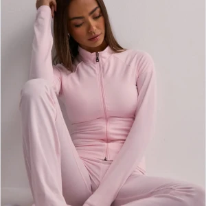 Ljusrosa zip top - Supermysig och stretchig träningströja från Nelly, använd en gång! Helt slutsåld på hemsidan 🩷