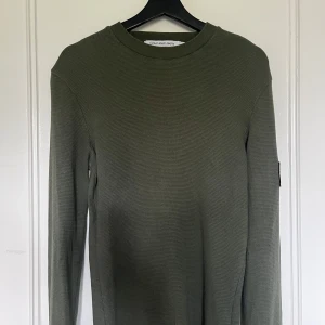 Mörkgrön tröja från Calvin Klein - Tja, säljer nu men tvärfeta mörkgröna långärmade tröjan från Calvin Klein Jeans. Helt ny men utan prislapp. Fick i present och var lite för liten. Använd en gång !!  Skit bra skick och finns inga skavanker. Priset är inte heller hugget i sten så bara att ge förslag. 