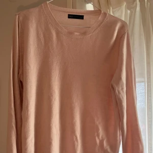 Ljusrosa stickad tröja från M&S - Supermjuk ljusrosa stickad tröja från M&S Collection. Tröjan har rund halsringning, långa ärmar och ribbade muddar vid ärmslut och nederkant. Perfekt för lager-på-lager och chill dagar. Skulle säga passar som en storlek M/L