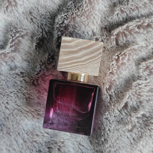 Rituals Nuit de l'Himalaya 15ml parfym - Snygg parfymflaska från Rituals, Nuit de l'Himalaya, 15 ml eau de parfum. Flaskan är fyrkantig i mörklila glas med en lyxig, träliknande ljus kork och gulddetaljer. Perfekt storlek att ta med i väskan.