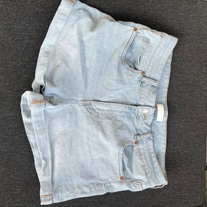 Ljusblå jeansshorts med uppvik - Snygga ljusblå jeansshorts med klassisk femficksdesign och uppvikta benslut. Finns ingen storleks lapp men tippar på strl 42