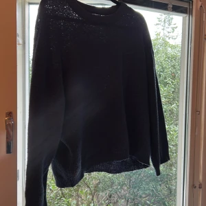 Mörkblå stickad tröja från 157 - Mysig mörkblå stickad tröja från 157 med rund halsringning och långa ärmar. Tröjan har en enkel och avslappnad passform, perfekt att slänga på sig när det är kyligt ute. Passar dig som gillar basic och stilrena plagg.