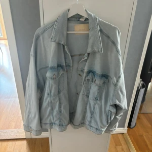 Oversized ljusblå jeansjacka från H&M - Säljer en oversized ljusblå jeansjacka från H&M. Jackan har klassisk krage, knäppning framtill och två bröstfickor. Perfekt för dig som gillar en chill och avslappnad stil. Passar snyggt till allt.