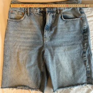 Ljusblå jeansshorts från Gina Tricit Perfect Jeans - Ljusblå jeansshorts från Perfect Jeans med klassisk femficksdesign och råa, fransiga benslut. Shortsen har normal passform och stängs med dragkedja och knapp. Perfekta för en avslappnad stil.