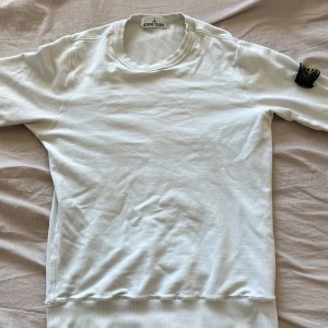 Stone Island tröja - Säljer denna vita Stone Island tröja i storlek S. skick 6-7/10 eftersom att i slutet av ärmarna är de lite små hål men går såklart att sy ihop enkelt om man vill de.