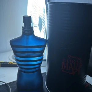 Jean Paul Gaultier Ultra Male Eau de Parfum 125ml - Säljer en Jean Paul Gaultier Ultra Male parfym i den ikoniska blå flaskan med svarta ränder, formad som en manlig torso. Kommer i original metalltub. Doften är intensiv och maskulin, perfekt för dig som gillar unika och kraftfulla parfymer. 125 ml. Pris kan diskuteras 