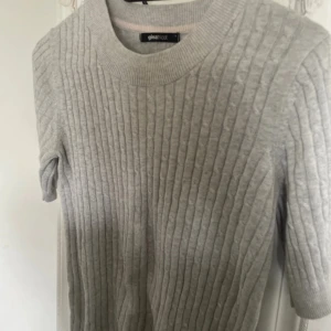 Ljusgrå ribbad tröja från Gina Tricot - Säljer en ljusgrå ribbad tröja från Gina Tricot. Tröjan har rund halsringning och är stickad med ett diskret kabelmönster. Perfekt för lager-på-lager och enkel att matcha med olika outfits.