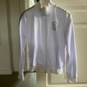 Vit track jacket från Fendi - I'm selling my really cool Fendi sweater🔥 I bought this from a cousin who got it as a birthday present. Unfortunately I don't have a receipt for it, but if you want to legit check, just ask for more pictures🤝 The sweater is size 42 which corresponds to sx-s👌 This sweater is from Nicki Minaj's Fendi drop😁 just ask if you have any questions🤩
