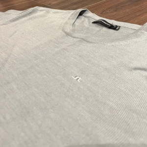 Ljusgrå tröja från J.Lindeberg i merinoull - Säljer en stilren ljusgrå tröja från J.Lindeberg. Tröjan har rund halsringning, diskret broderad logga på bröstet. Perfekt för en clean och klassisk look. Nypris 1300kr. Tveka inte på att kontakta vid funderingar🤝🏼