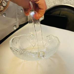 korgformad godisskål i glas - Säljer en unik och elegant korgformad godisskål i glas med dekorativt mönster och handtag. Skålen har vackra detaljer och ett klassiskt utseende.