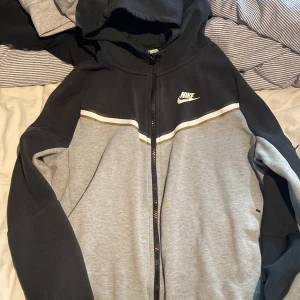 Nike tech fleece grå/svart - Säljer en grå/svart Nike tech fleece! Den är i ganska bra skick men fortfarande använd.hör av er vid frågor!