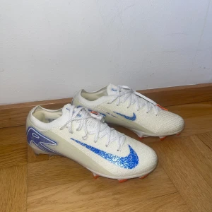 Nike Air Zoom Mercurial Vapor 16 Elite FG Blueprint  - Nike Air Zoom Mercurial Vapor 16 Elite FG Blueprint – Storlek 41😮‍💨😮‍💨 Säljer ett par Nike Air Zoom Mercurial Vapor 16 Elite FG i den populära “Blueprint”-designen i vit/blå. 🤝Dessa är toppmoderna fotbollsskor för spel på naturgräs och gräs✅✅. Storlek 41, i nyskick,“oanvända”🤑🤑  Nypris: ca 3500-4200 kr 
