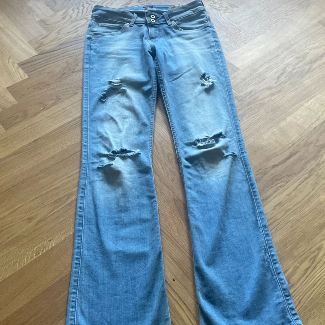 Lågmidjade ljusblå slitna jeans från Lee