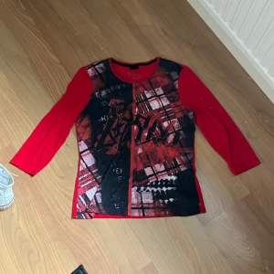 röd tröja med svart tryck - röd tröja med svart tryck på framsidan . ärmarna är trekvartslängd
