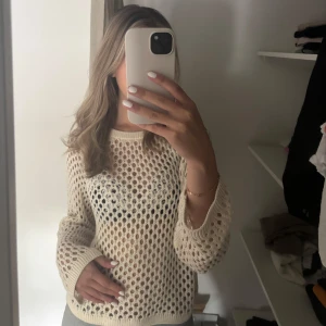 Beige stickad tröja från BikBok - Säljer en vit stickad tröja från BikBok i storlek S. Tröjan har ett hålmönstrat stickat material och långa ärmar. Perfekt för lager-på-lager och ger en trendig look. Har endast använt den någon enstaka gång och är därför jag säljer den. Personligen skulle jag säga att den är ett perfekt strandplagg❤️