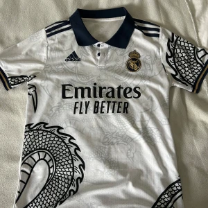 Real Madrid dragon t-shirt - Ream madrid dragon t-shirt som ör i väldigt bra skikt . Lägger bra pris för den. Några säljer likadana men de är inte i lika bra skikt som den här är👍