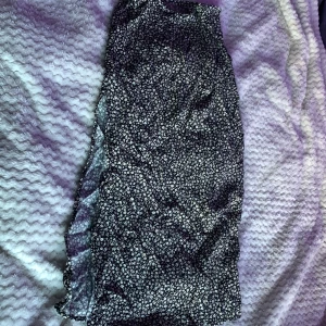 Svart blommig långkjol från H&M - Säljer en svart långkjol från H&M med vitt blommönster. Kjolen har dragkedja bak och är i ett lätt, flowy material som passar perfekt till varmare dagar. Stilren och enkel att matcha med olika toppar.