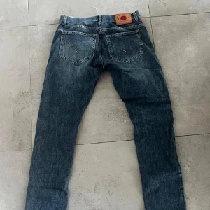 Blå jeansbyxor från Levis 501 - Klassiska blå jeansbyxor från Levis 501 med raka ben och femficksmodell. Byxorna har normal passform och är tillverkade i slitstarkt denim. Perfekta för en avslappnad stil.