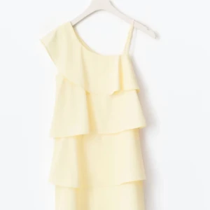 Ljusgul volangklänning  - Slutsåld ljusgul klänning med flera volanger och oneshoulder. Klänningen har en axelbandslös sida och ett smalt axelband på andra sidan som man även kan klippa av om man inte vill ha💛Köpt på Gina Tricot young för 300kr, helt ny aldrig använd. Kontakta mig gärna för frågor💕Jag säljer två olika, en strl 164 och en strl 158.