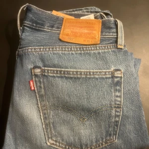 Levi's 501 blå jeans - Klassiska blå Levi's 501 jeans med rak passform och femficksdesign. Skriv för mer bilder.