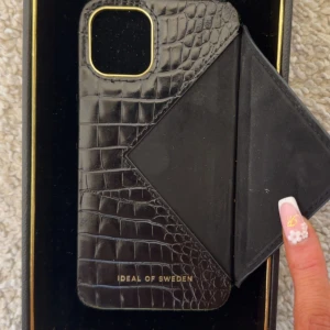 Svart Ideal of Sweden mobilskal - Jättefint mobilskal med korthållare. Några stötar (se på bilderna). Nypris 700💕till iPhone 11 Pro tror jag🥰