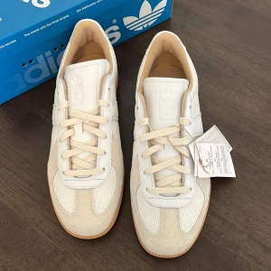 Adidas BW Army Lux vita sneakers *NYA* - Snygga Adidas BW Army Lux sneakers i vitt skinn med beige detaljer och klassisk gummisula. Nypris 1645. Svår att få tag i då modellen är populär.